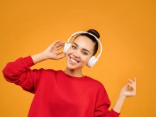 woman in red sweater wearing white headphones