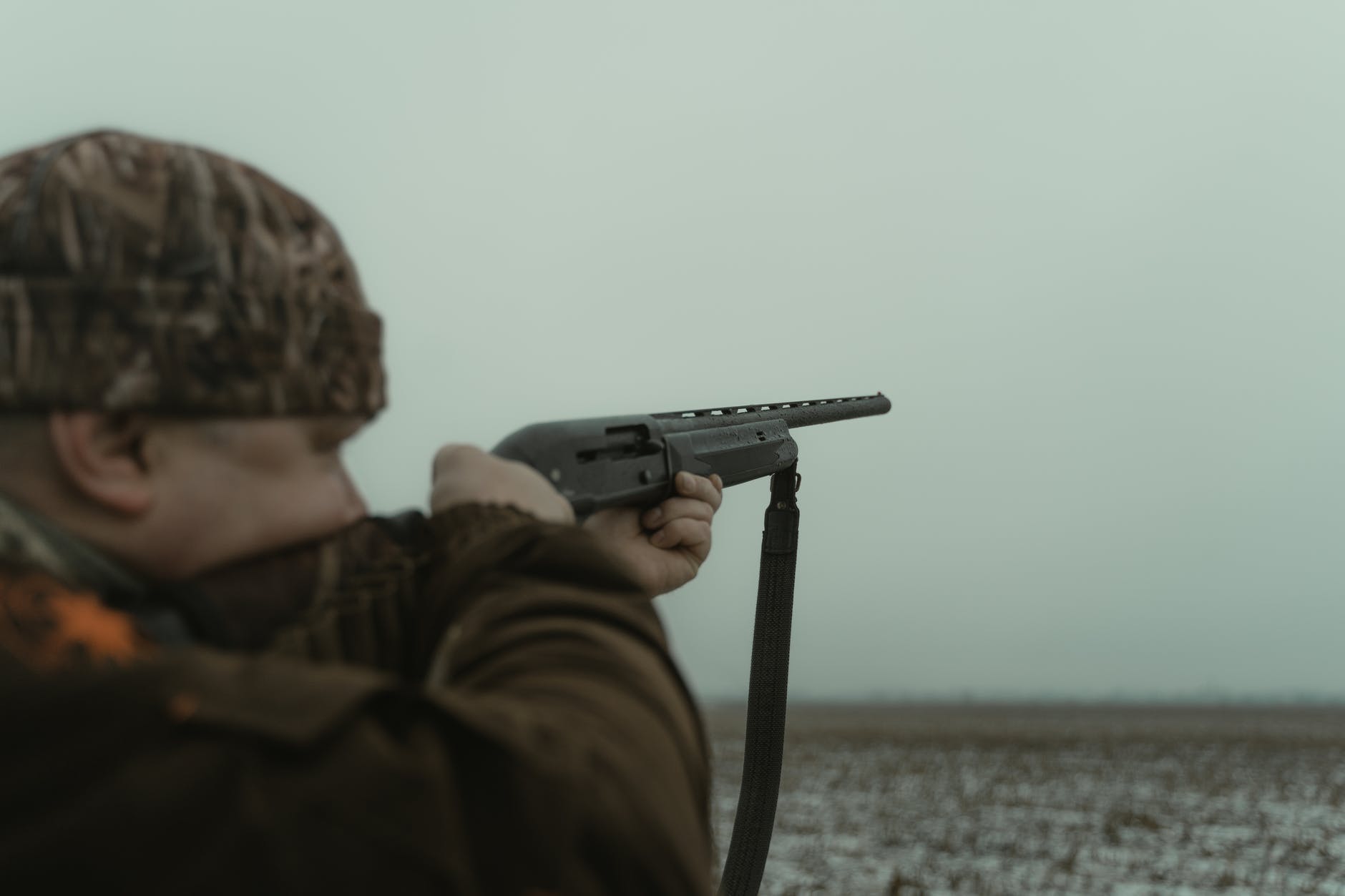 photograph of a hunter using a black shotgun